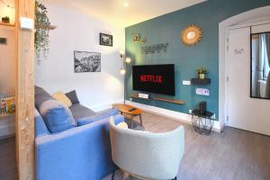 a living room with a blue couch and a tv at Au Bretzel Doré - Centre Historique in Colmar