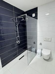 a bathroom with a glass shower and a toilet at Rubinas Apartment in Prizren +44 photos