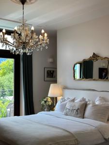a bedroom with a large white bed with a chandelier at Villa Pomona in Bled