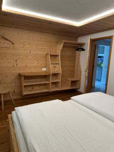 a bedroom with two beds and a wooden wall at Apart Alpenpension Maderer in Gaschurn +92 photos