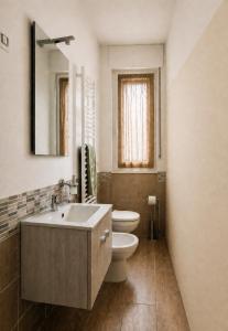 a bathroom with a sink and a toilet and a mirror at Home Istria 81 in Trieste