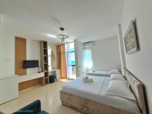 a bedroom with a large bed and a television at Eden Hotel in Shëngjin
