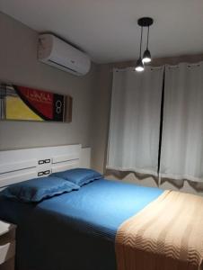 a bedroom with a bed with blue sheets and a window at Apto 02 Quartos Mobiliado na Praia do Poço - CABEDELO in Cabedelo +7 photos