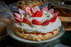 a cake with strawberries on top on a plate at Pousada Gauleses - Refugio de Charme na Praia do Rosa by La Vem Férias in Praia do Rosa +60 photos