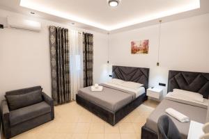 a hotel room with two beds and a chair at Villa Bella in Ksamil