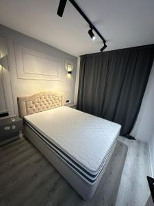 a bedroom with a white bed in a room at Renovat si stilat pentru un sejur de exceptie in Ungheni