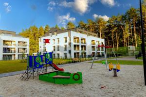 ein Spielplatz im Sand vor einem Gebäude in der Unterkunft Morze Słońca in Łukęcin