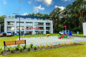 ein Spielplatz vor einem Gebäude mit einem Gebäude in der Unterkunft Morze Słońca in Łukęcin