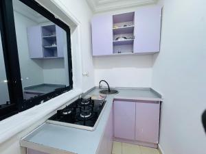 a kitchen with a stove and a window at La Castrol Hotel Apartments in Limbe