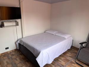 a bedroom with a bed and a flat screen tv at donde la abuela Josefa in Quimbaya