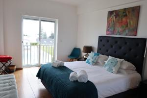 a bedroom with a large bed with towels on it at CASA SIMBA , where the fun begins in Ponta Delgada +69 photos