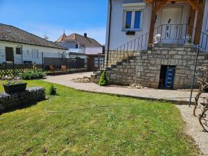 a yard with a hose in the grass in front of a house at Klein Haus 12A in Sulzbach-Rosenberg