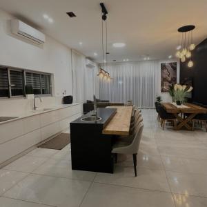 a kitchen and dining room with a table and a dining room at Geron's וילת אירוח in Bet Sheʼan