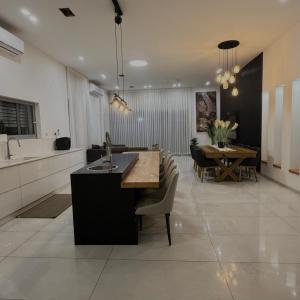 a kitchen and dining room with a sink and a table at Geron's וילת אירוח in Bet Sheʼan
