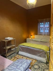 un dormitorio con una cama y una ventana en Tigmi Timhar, en Nkob