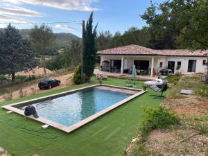 a house with a swimming pool on a green lawn at suite romantique jacuzzi & piscine privée en pleine forêt in Saint-Zacharie