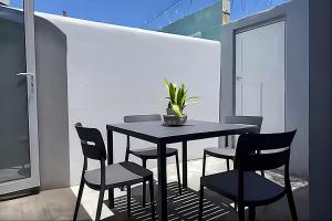 a dining room table with chairs and a plant on it at Evangeline House in Cape Town