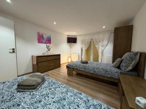 a bedroom with two beds and a table and a window at Attic Apartment in Kočovce