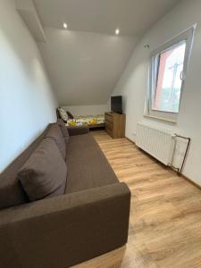 a living room with a couch and a television at Attic Apartment in Kočovce