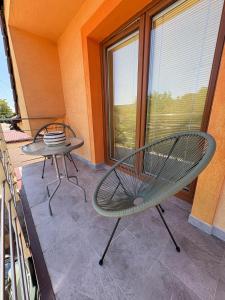 a patio with two chairs and a table and a window at Attic Apartment in Kočovce