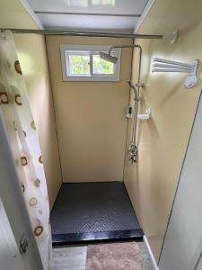 a shower in a small room with a window at Family Wolf - El Chorro in Paquera +15 photos