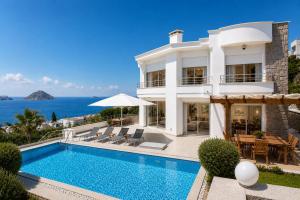 a villa with a swimming pool and the ocean at Villa Azure Heaven in Turgutreis