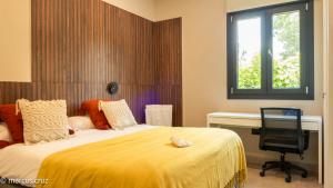 a bedroom with a bed and a desk and a chair at Poniente Beach House in Chiclana de la Frontera +73 photos