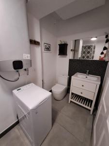 a white bathroom with a toilet and a sink at Górska Otulina in Wilkowisko