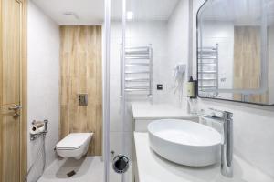 a white bathroom with a sink and a toilet at Marina Club in Batumi +10 photos