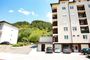 a large apartment building with cars parked in a parking lot at Sara Luxe Family in Konjic
