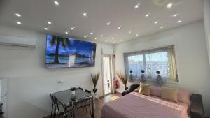 a living room with a bed and a tv on the wall at Un Tuffo nello Stretto in Villa San Giovanni