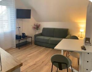 a living room with a couch and a table and chairs at Ourmes 1 Apartment in Guipry-Messac
