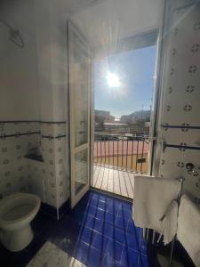 a bathroom with a toilet and a balcony with a view at Casa Castellano in Naples