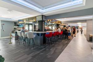 a bar in a restaurant with people standing around it at 2BR Condo with Golf Views Near Sunset Beach in Sunset Beach