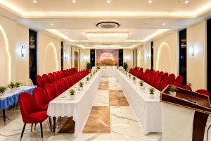 a long table in a room with red chairs and tables at Hotel avadh classio near by ram mandir in Faizābād