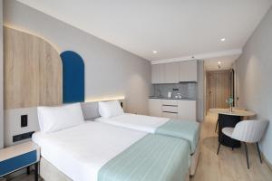 a bedroom with a large bed and a kitchen at Marina Club in Batumi