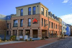 a brick building with a red sign on it at Bernstein Suite & Breakfast Apartment 05 in Büsum