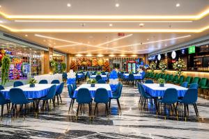 a banquet hall with tables and blue chairs at Hotel avadh classio near by ram mandir in Faizābād