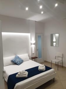 a bedroom with a bed with a blue pillow and a chair at B&B Colori del Salento in Presicce