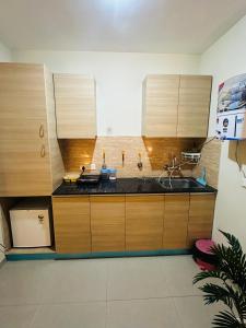 a kitchen with wooden cabinets and a sink at Kishori Ji Homes in Chhatikara +33 photos