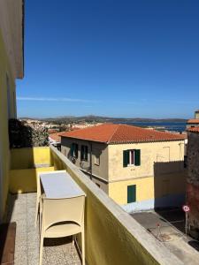 a table and chair on a balcony with a view at Casa Balilla in La Maddalena