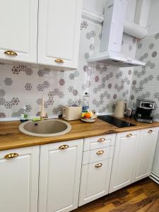 a kitchen with white cabinets and a sink at November Central Studio in Lugoj