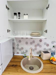 a kitchen with a sink in the middle of a counter at November Central Studio in Lugoj +3 photos