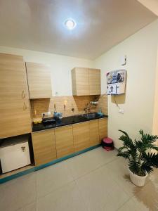 a kitchen with wooden cabinets and a sink and a potted plant at Kishori Ji Homes in Chhatikara