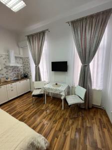 a bedroom with a table and a television in it at November Central Studio in Lugoj