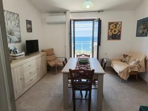 a living room with a dining room table with a view of the ocean at Appartamento - Plemmirio - Villa Maria Serena in Syracuse