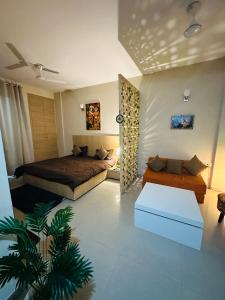 a bedroom with a bed and a couch at Kishori Ji Homes in Chhatikara