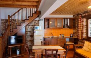 a kitchen and dining room with a table and a staircase at Alexis new villas in Chrysi Ammoudia