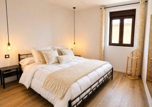 a bedroom with a large bed with white sheets and pillows at fuga romantica in Benisuera
