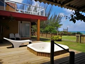 a bath tub sitting on a deck next to a house at Pousada Estaleiro Village - Frente Mar in Balneário Camboriú